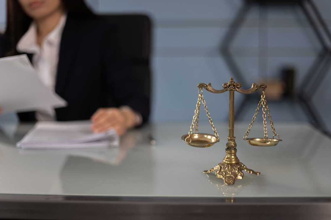 A set of balance scales sits on a desk in a lawyers' office. A set of balance scales sits on a desk in a lawyers' office.