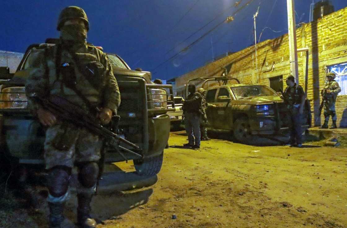Mexican troops stand guard at the scene of a gun battle between police and suspected criminals in El Salto in western Mexico Mexican troops stand guard at the scene of a gun battle between police and suspected criminals in El Salto in western Mexico