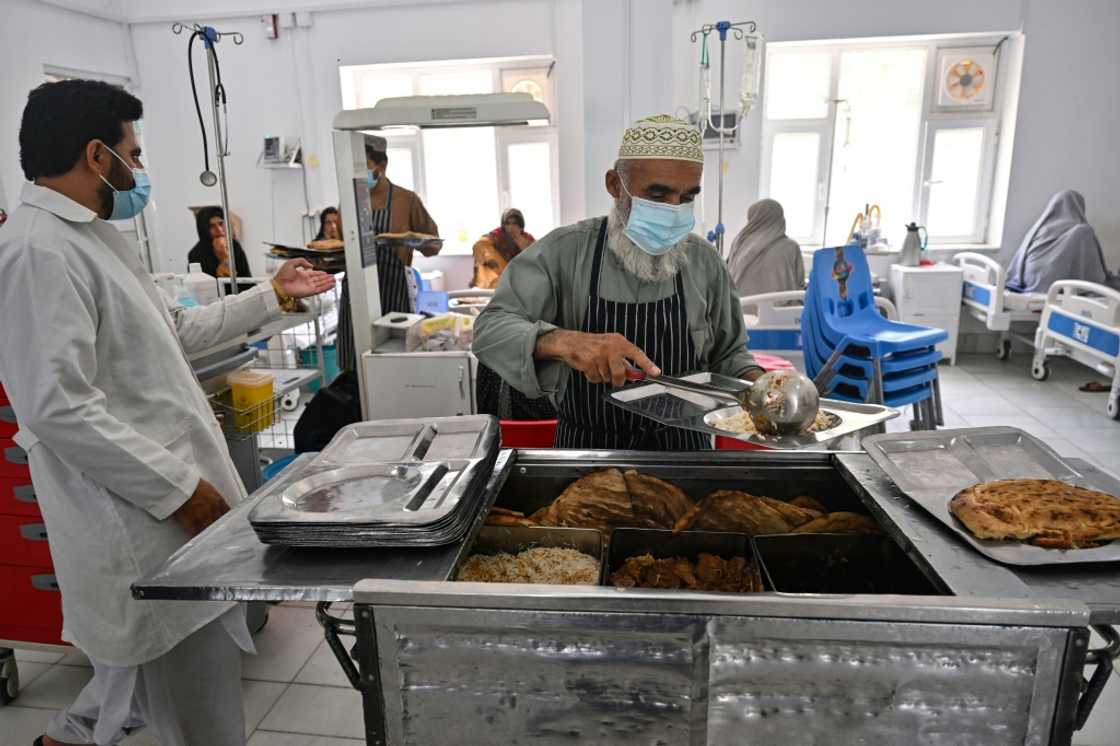 A staff member serves food to the doctors and nurses working in the critical care section of the malnutrition ward at Boost Hospital A staff member serves food to the doctors and nurses working in the critical care section of the malnutrition ward at Boost Hospital