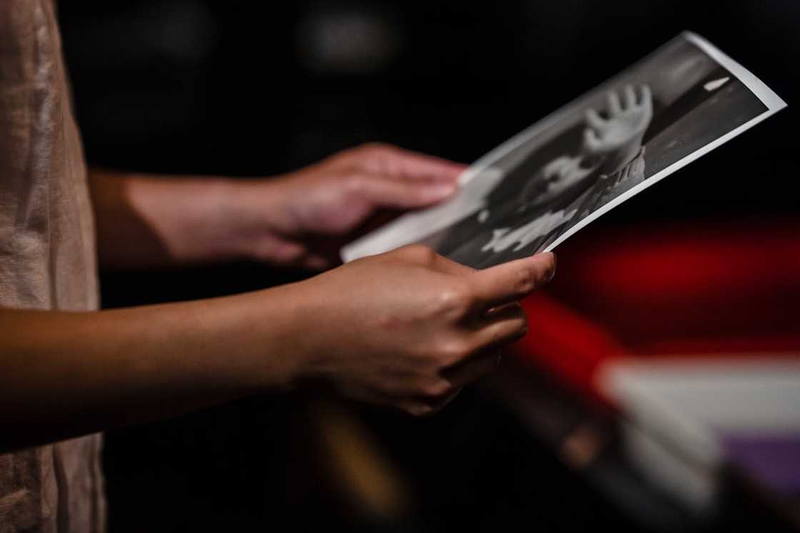 A woman holding old letters and photographs.