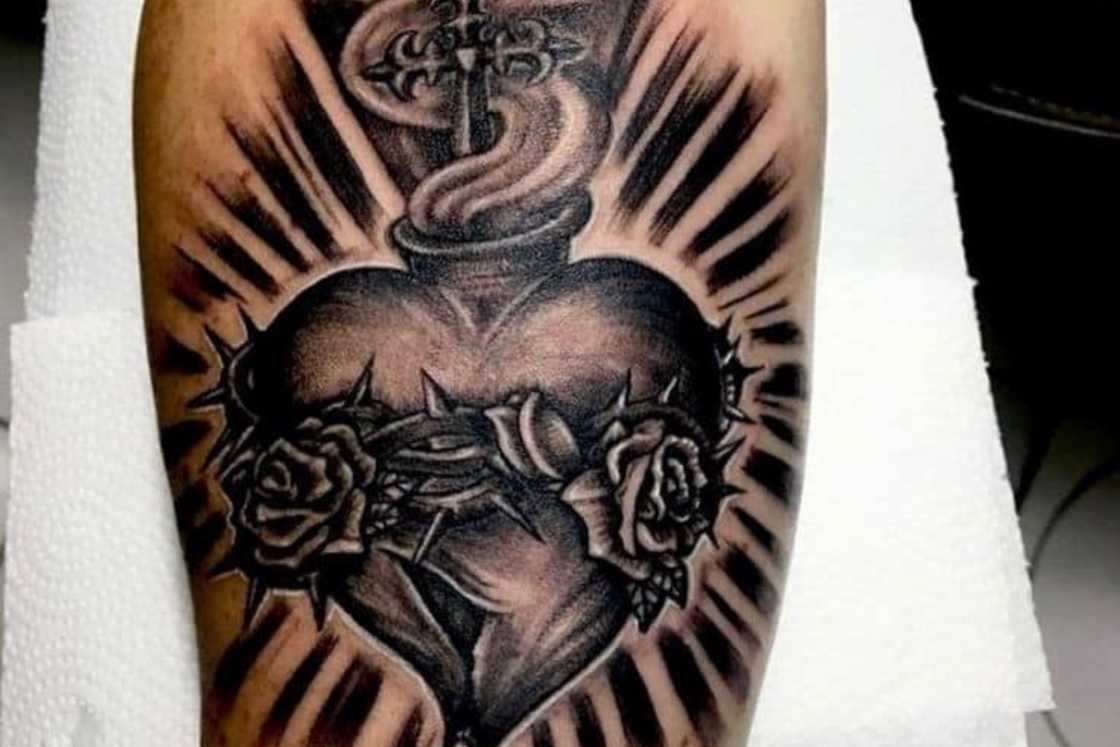 A black and white heart of thorns forearm tattoo