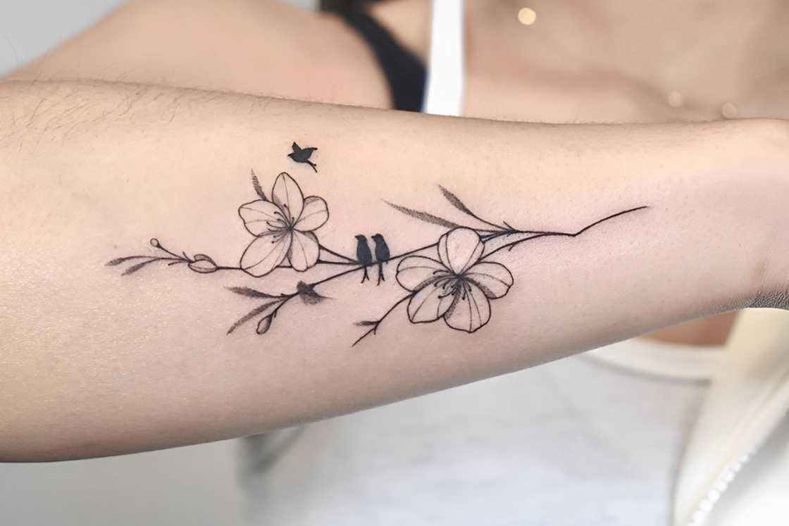 A woman with a simple cherry blossom tattoo on the hand