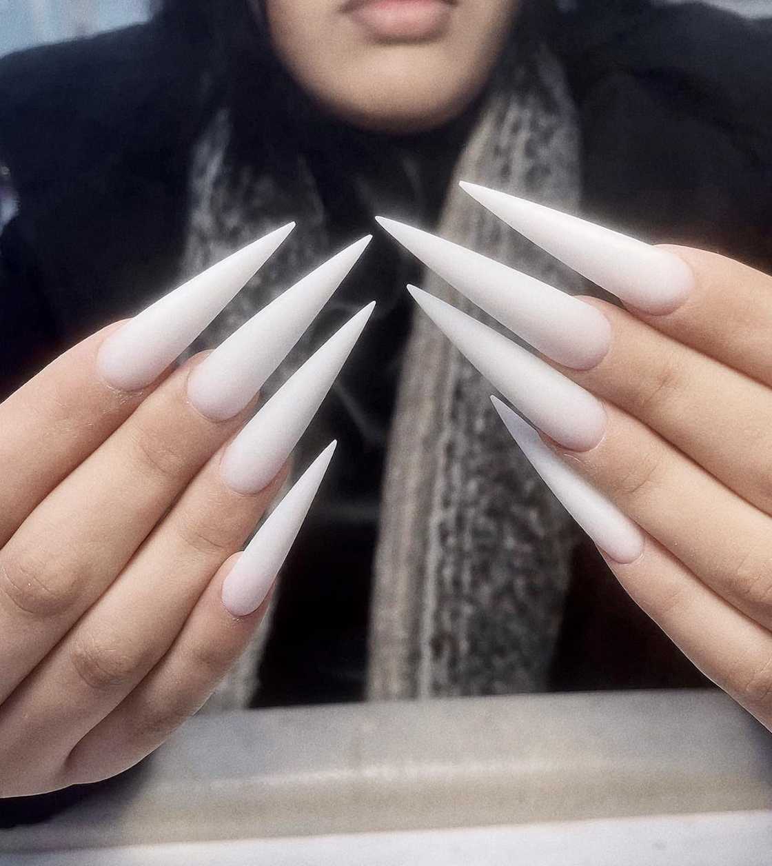 Lady showing off her stiletto milky nails