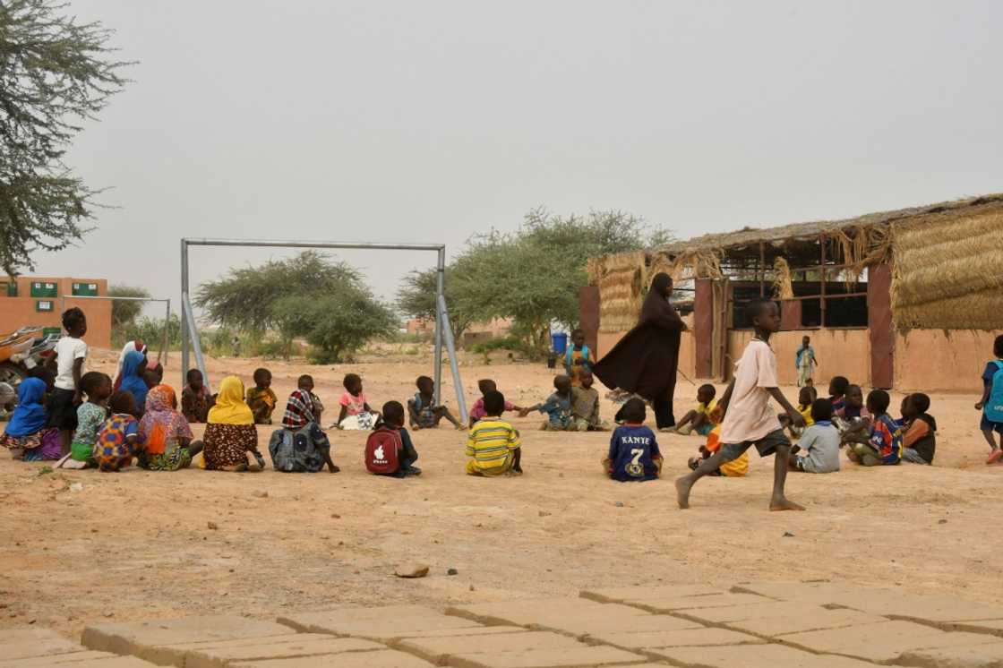 Time for play: A teacher and her pupils in the yard of a school set up for displaced children Time for play: A teacher and her pupils in the yard of a school set up for displaced children