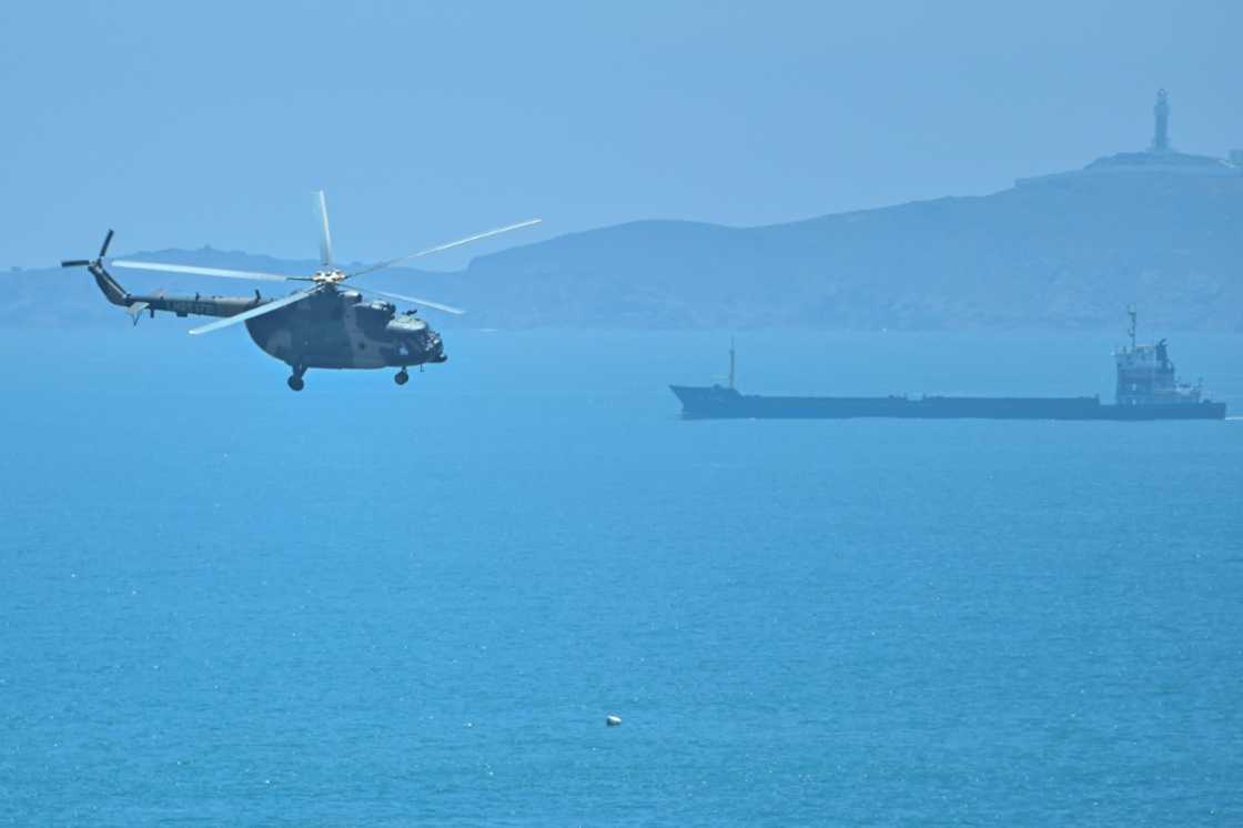 A Chinese military helicopter flies past Pingtan island, one of mainland China's closest points from Taiwan, in Fujian province on August 4, 2022 ahead of massive military drills off Taiwan following US House Speaker Nancy Pelosi's visit