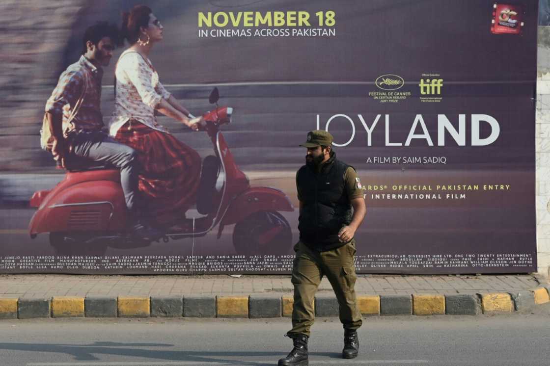 A policeman walks past a promotional banner of Pakistan-produced movie "Joyland" in Lahore on November 16, 2022 A policeman walks past a promotional banner of Pakistan-produced movie "Joyland" in Lahore on November 16, 2022