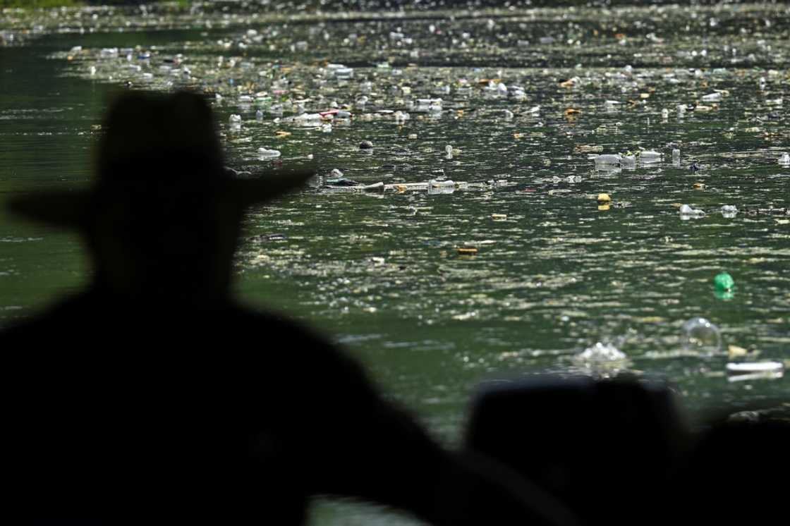 A fisherman looks out over the carpet of plastic waste covering the Cerron Grande reservoir in Potonico, El Salvador A fisherman looks out over the carpet of plastic waste covering the Cerron Grande reservoir in Potonico, El Salvador