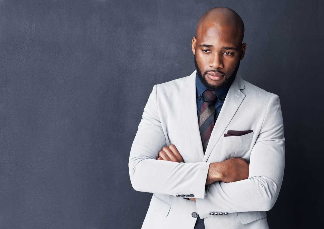 A man looking thoughtful against a gray background A man looking thoughtful against a gray background