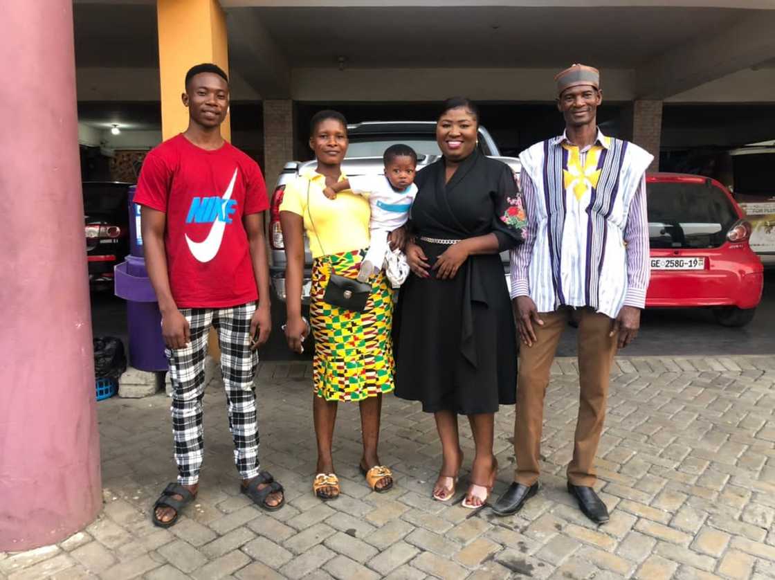 Ghanaian journalist Regina Asamoah poses with stolen but found boy and his family.