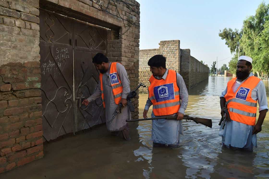 Armed members of a local Muslim charity patrol flooded streets to check abandoned houses for looting in Nowshera, in Pakistan's north Armed members of a local Muslim charity patrol flooded streets to check abandoned houses for looting in Nowshera, in Pakistan's north