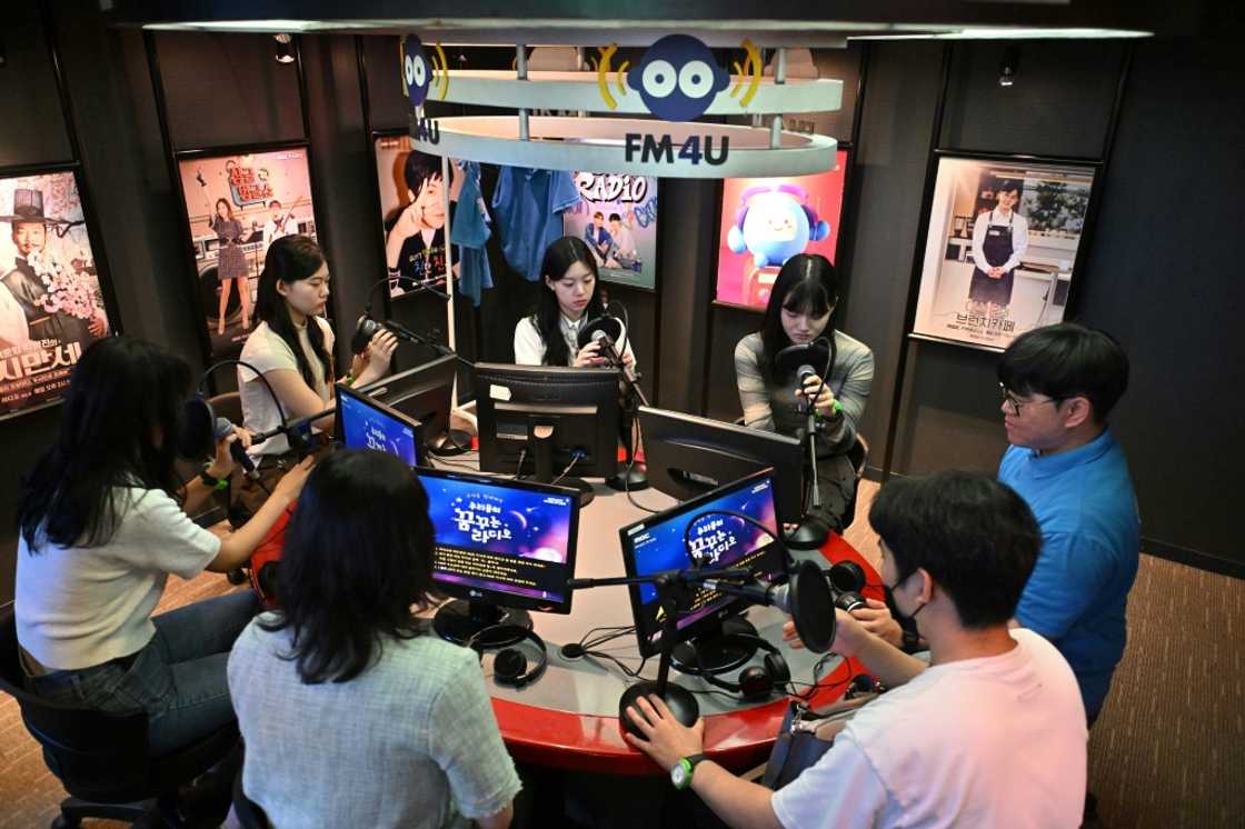 Visitors practice their radio DJ skills in a mock studio at KidZania Visitors practice their radio DJ skills in a mock studio at KidZania