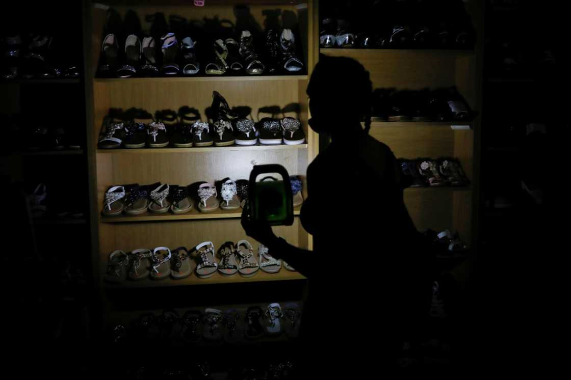 Go with the glow: A shopper uses a rechargeable LED lamp to illuminate a shoe rack Go with the glow: A shopper uses a rechargeable LED lamp to illuminate a shoe rack