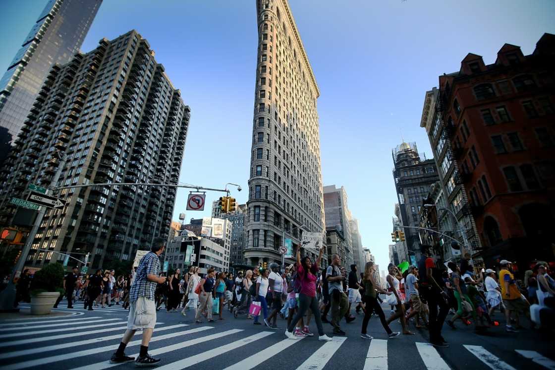 People march past the iconic Flatiron Building in New York People march past the iconic Flatiron Building in New York