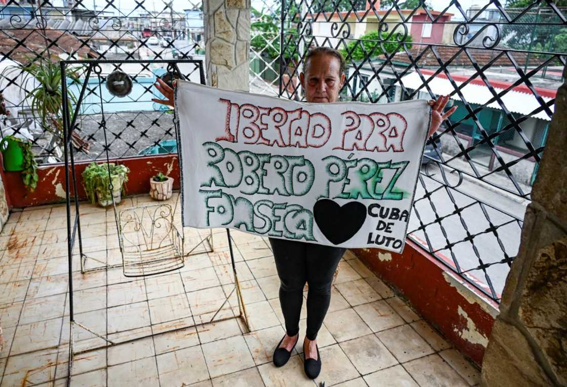 Liset Fonseca, mother of Roberto Perez Fonseca, also detained in the 2021 protests, shows a poster demanding the release of her son