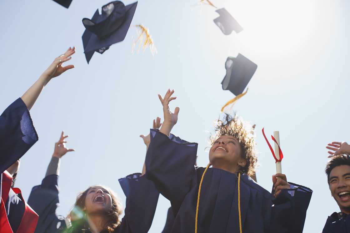 Graduates tossing caps into the air