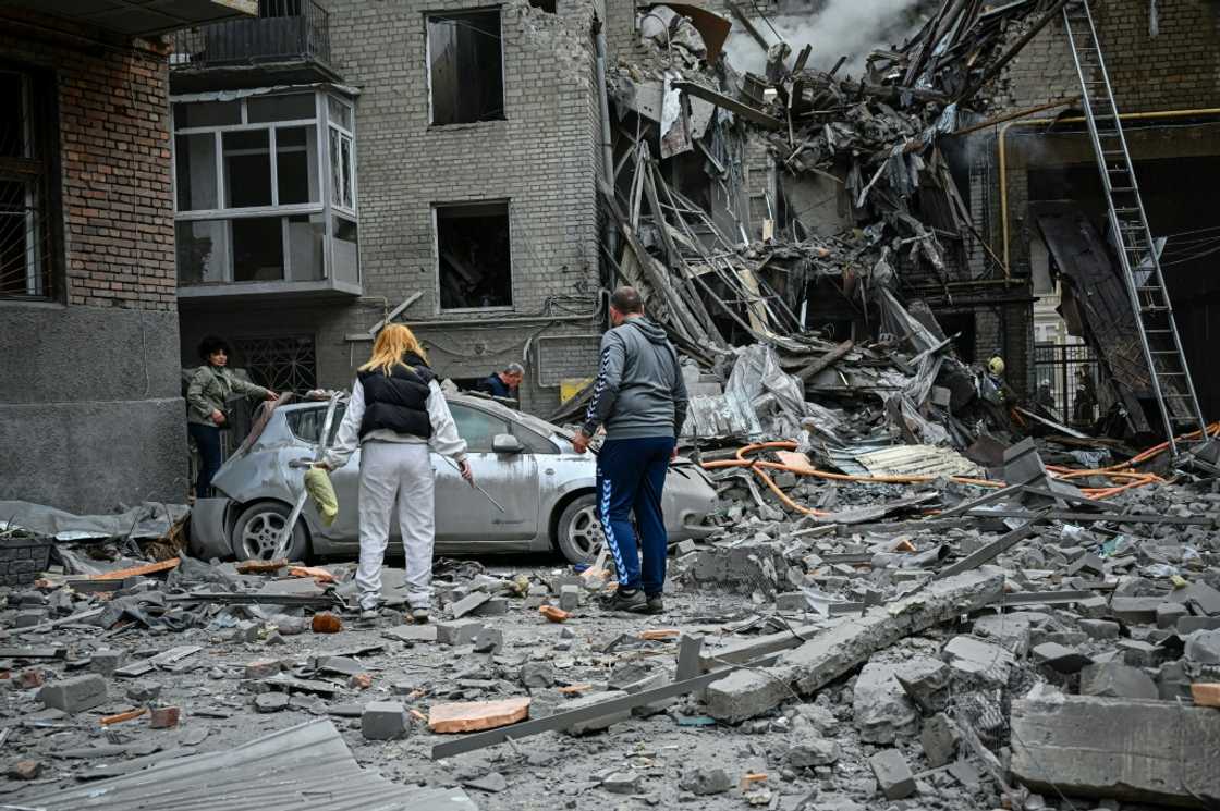 Residents amid the rubble after an apartment was hit by a missile strike in Kharkiv on September 6, 2022 Residents amid the rubble after an apartment was hit by a missile strike in Kharkiv on September 6, 2022