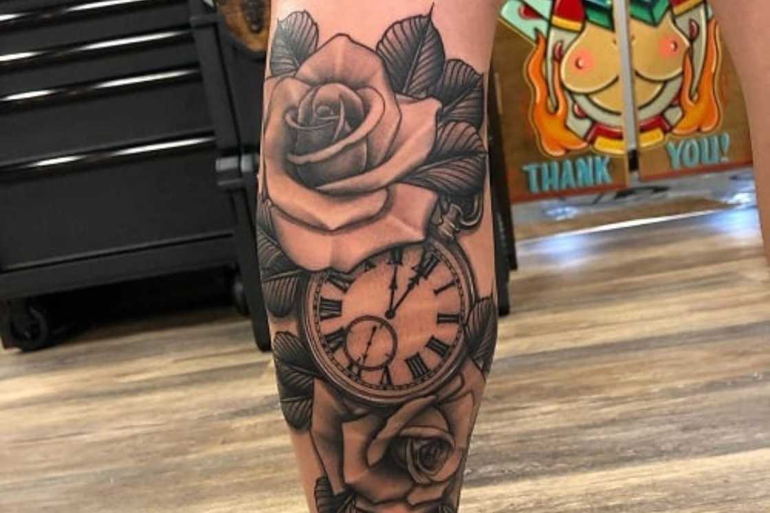 A black and grey rose and clock leg tattoo A black and grey rose and clock leg tattoo