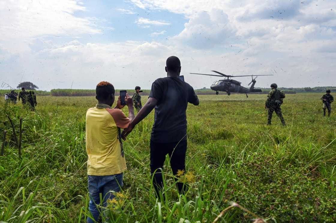 A man and a teenager record with their mobile phones the landing of a Colombian Army helicopter as soldiers stand guard in Tetillo near Corinto, department of Cauca, Colombia A man and a teenager record with their mobile phones the landing of a Colombian Army helicopter as soldiers stand guard in Tetillo near Corinto, department of Cauca, Colombia