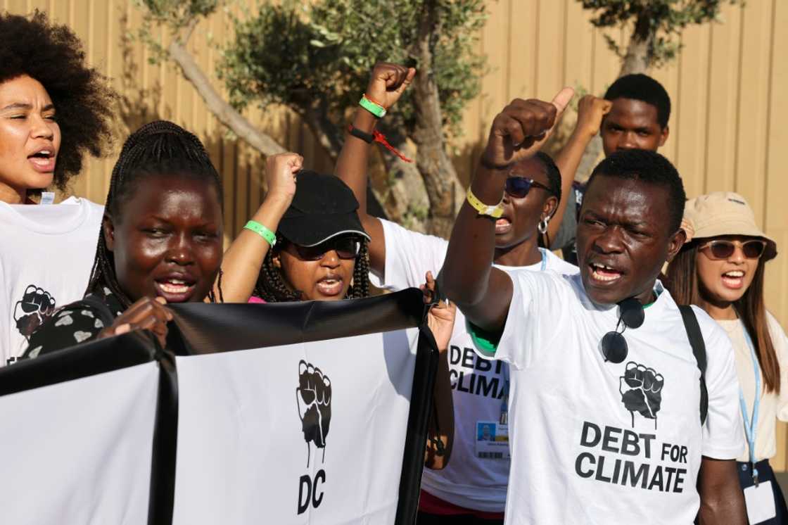 Activists lift banners as they stage a protest during the COP27 climate conference in the Egyptian Red Sea resort of Sharm el-Sheikh