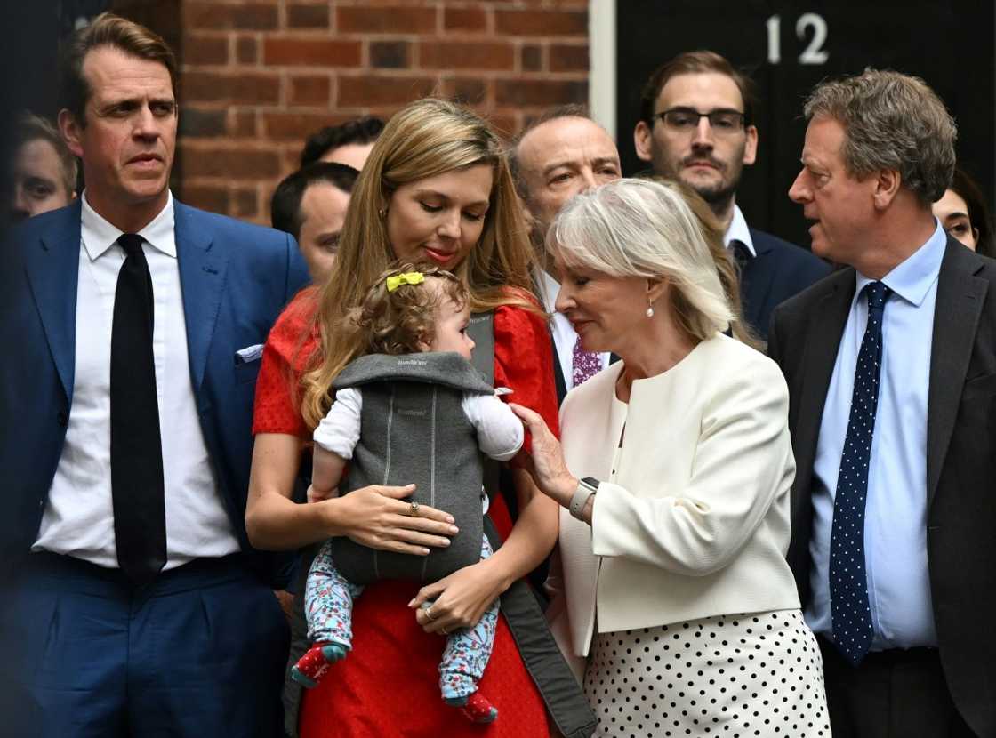 Johnson's wife Carrie, carrying their daughter Romy, watched his speech, flanked by Culture Secretary Nadine Dorries and Downing Street staff Johnson's wife Carrie, carrying their daughter Romy, watched his speech, flanked by Culture Secretary Nadine Dorries and Downing Street staff