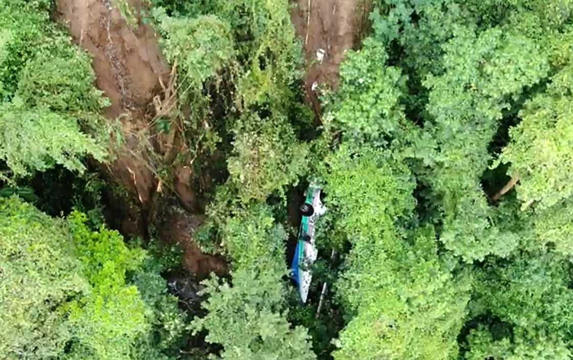 A bus that was pushed off a cliff by a landslide is seen in an image made available by Costa Rica's Fire Department