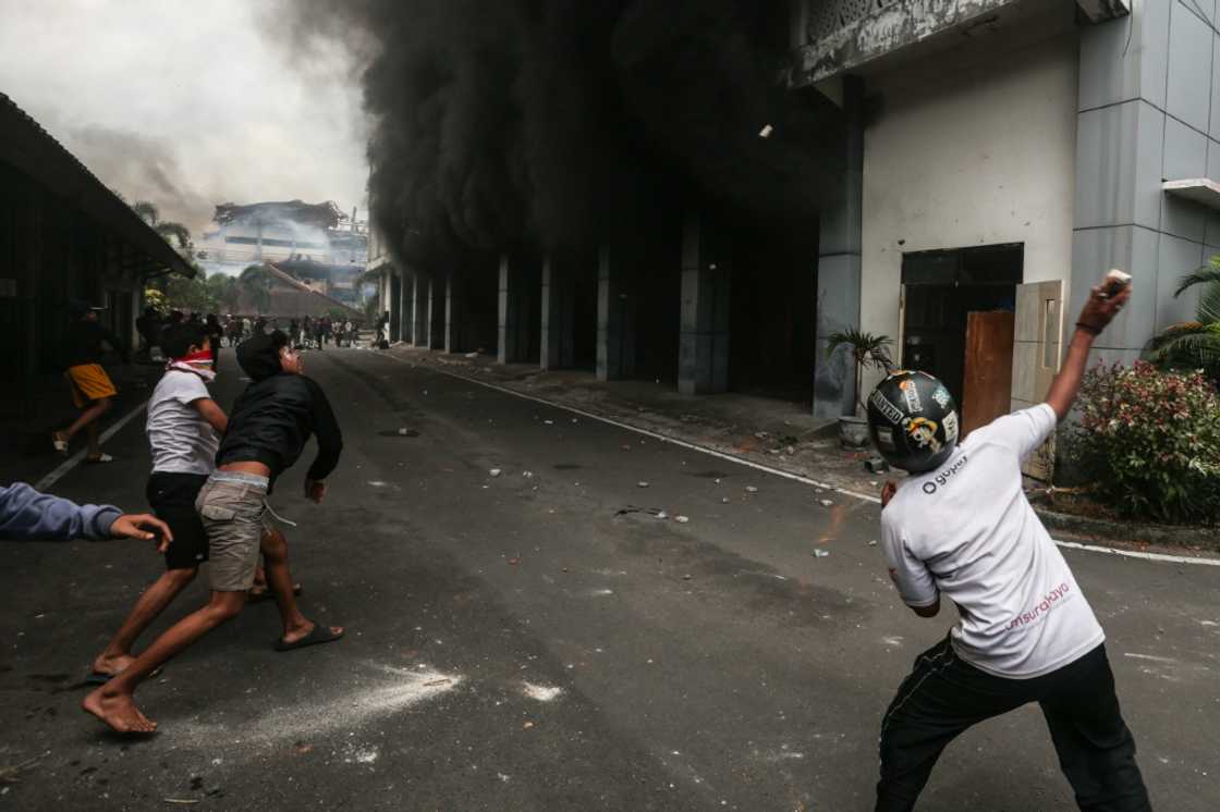 Protesters throw stones at a local council building on Lombok island Protesters throw stones at a local council building on Lombok island