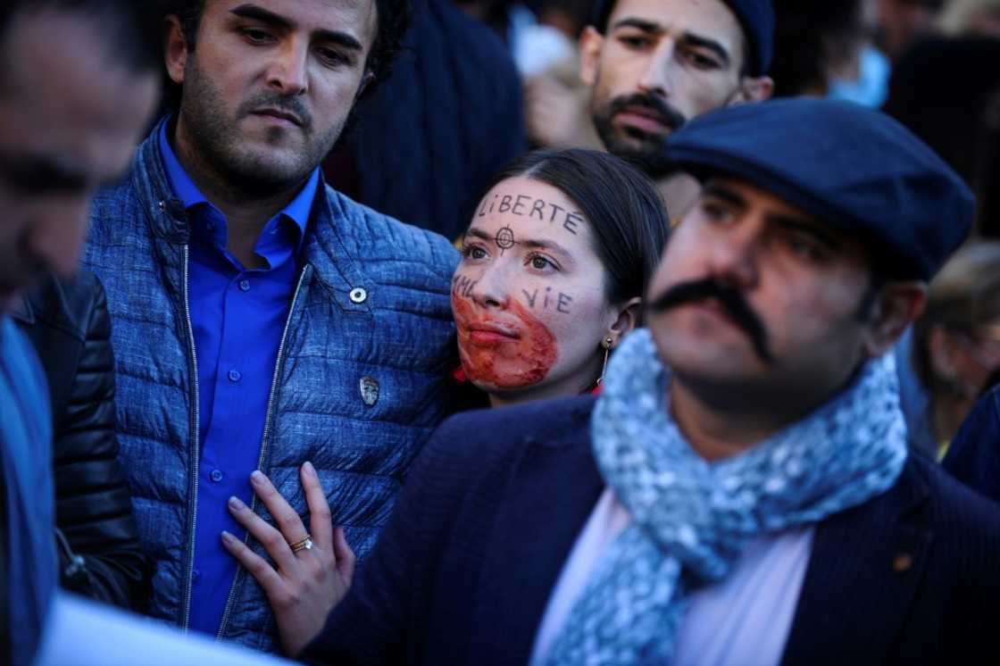 A demonstrator with a red hand painted on her mouth and "Freedom" written on her forehead attends a rally in support of Iranian protests in Paris A demonstrator with a red hand painted on her mouth and "Freedom" written on her forehead attends a rally in support of Iranian protests in Paris