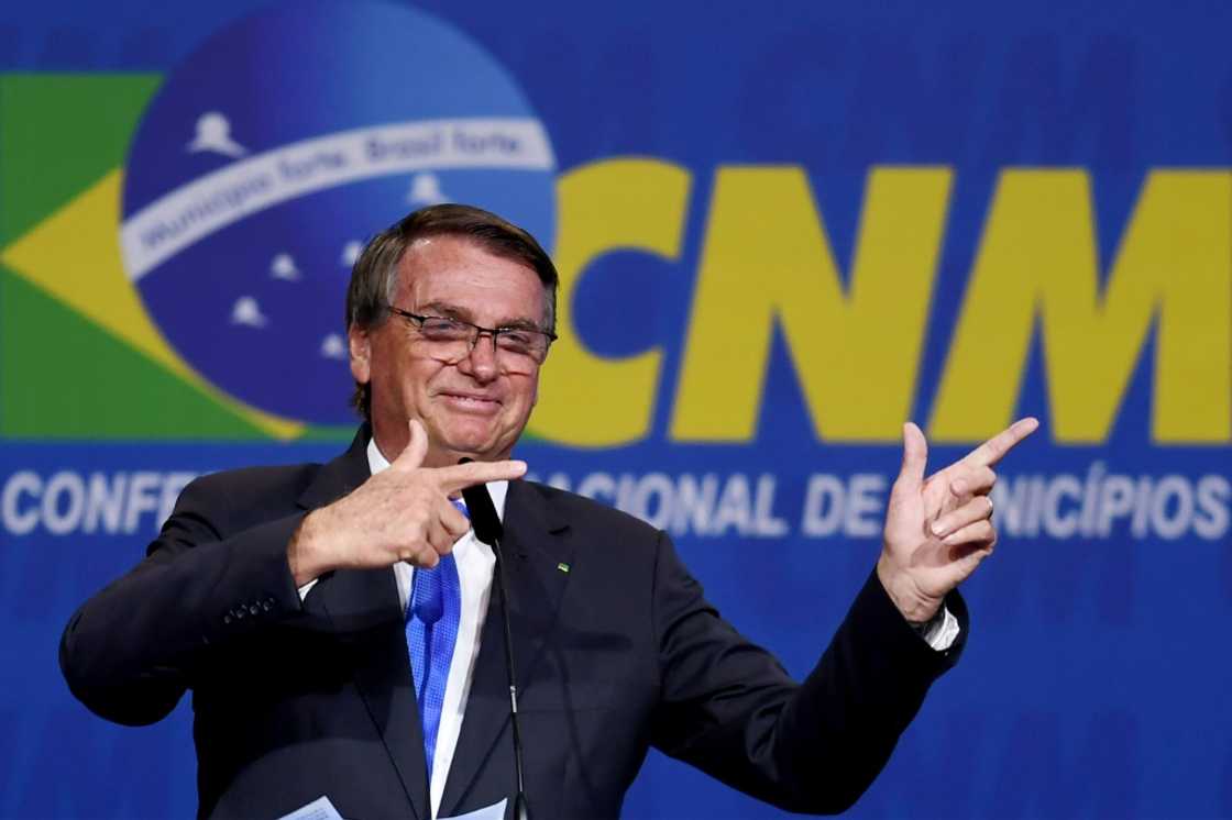 Brazilian President Jair Bolsonaro makes his signature 'pistol' gesture during an appearance in April 2022 in Brasilia Brazilian President Jair Bolsonaro makes his signature 'pistol' gesture during an appearance in April 2022 in Brasilia