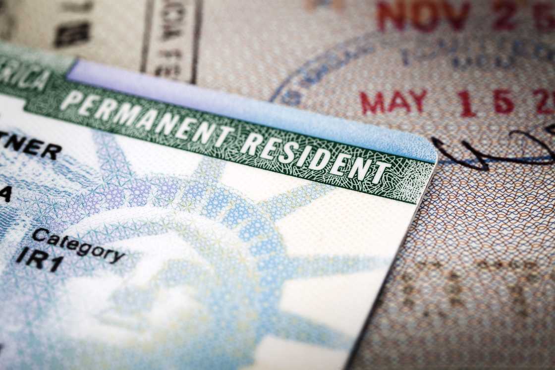 A Green Card lying on an open passport A Green Card lying on an open passport