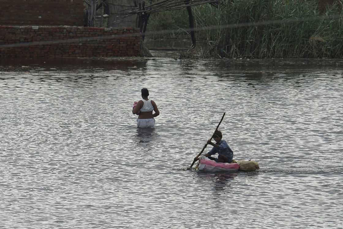 A child makes his way on a makeshift raft across flooded farmland near Sukkur, Sindh province A child makes his way on a makeshift raft across flooded farmland near Sukkur, Sindh province
