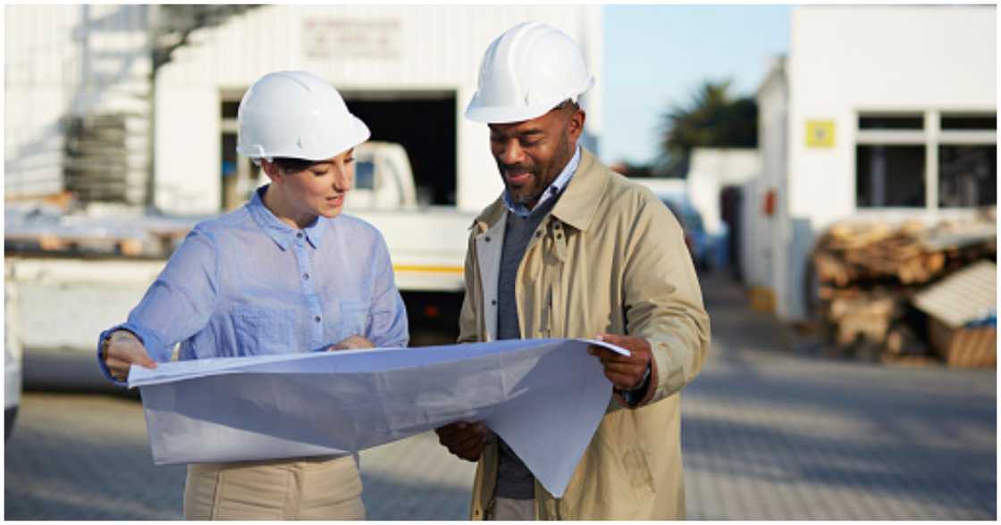 Two people looking at blueprints