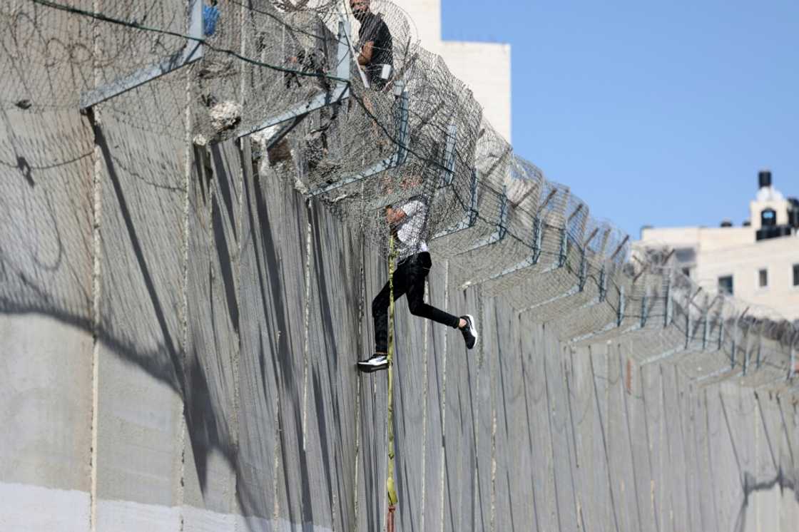 A youth descends Israel's controversial separation barrier into East Jerusalem A youth descends Israel's controversial separation barrier into East Jerusalem