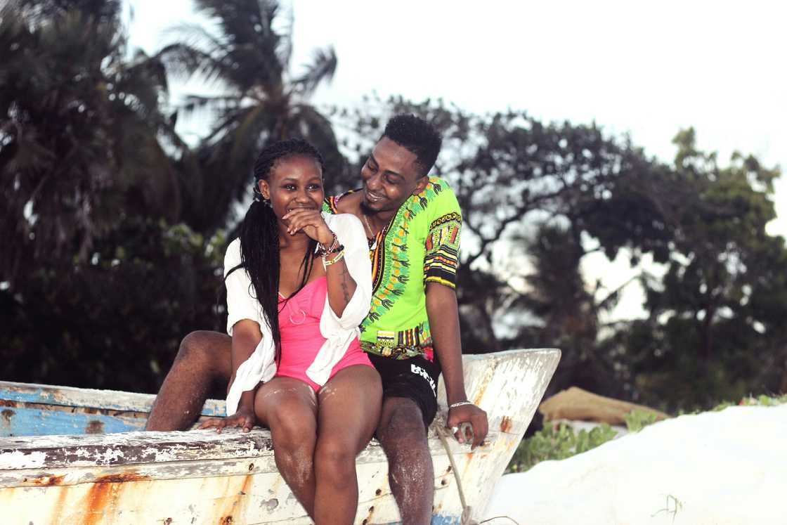 A young black couple sitting on a boat
