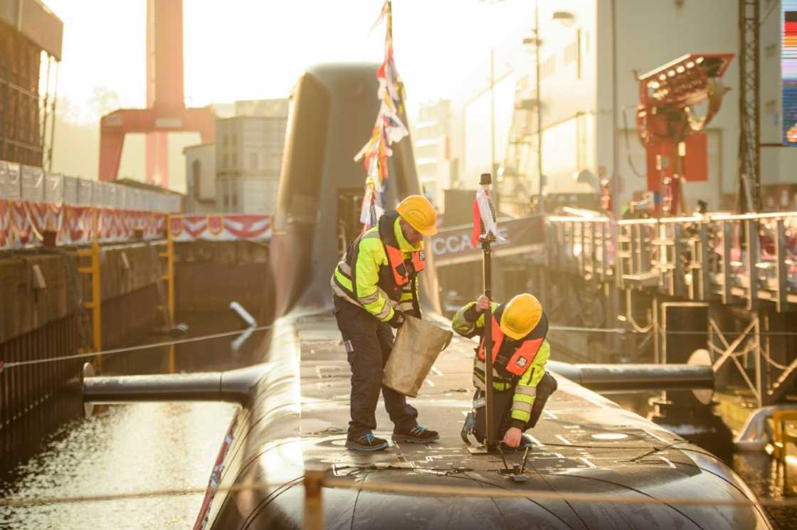 Workers at the thyssenkrupp marine systems shipyard ahead of the christening of a submarine for Singapore's navy, in Kiel, northern Germany, on December 13, 2022 Workers at the thyssenkrupp marine systems shipyard ahead of the christening of a submarine for Singapore's navy, in Kiel, northern Germany, on December 13, 2022