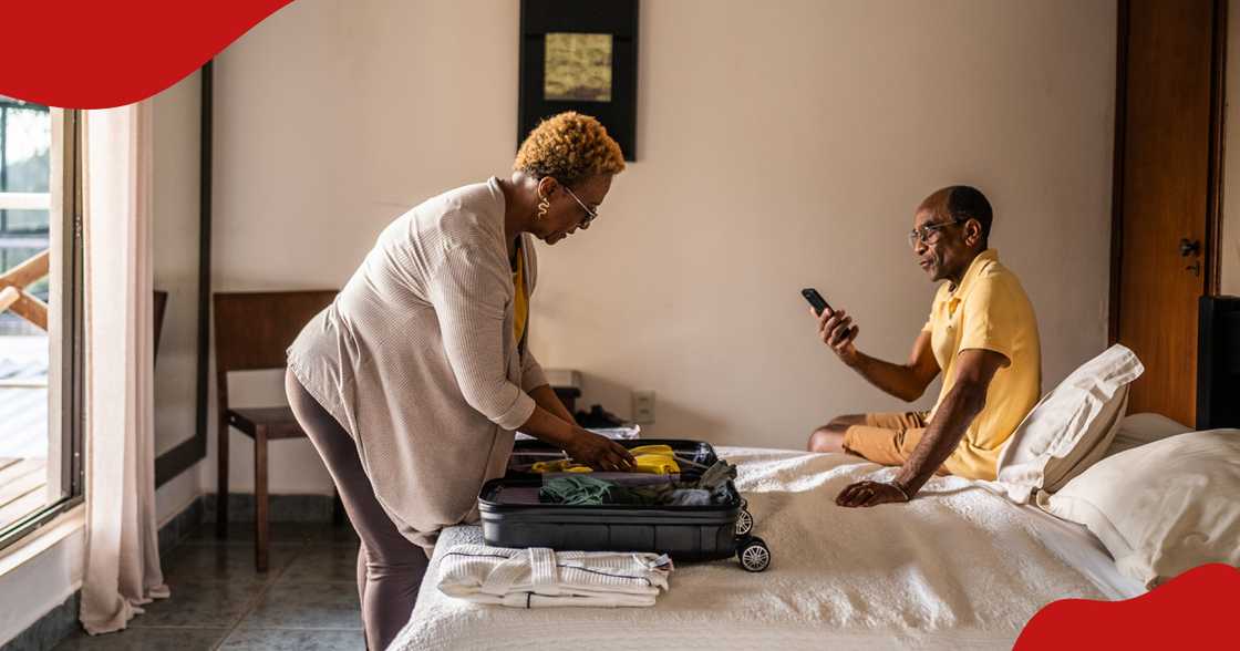 Photo of woman unpacking luggage while talking to a man in a hotel room. Photo of woman unpacking luggage while talking to a man in a hotel room.