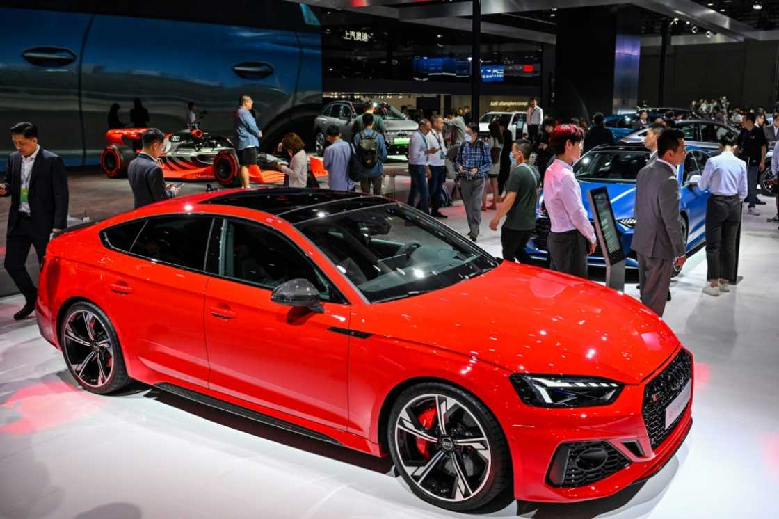 People visit a booth at the Shanghai Auto Show