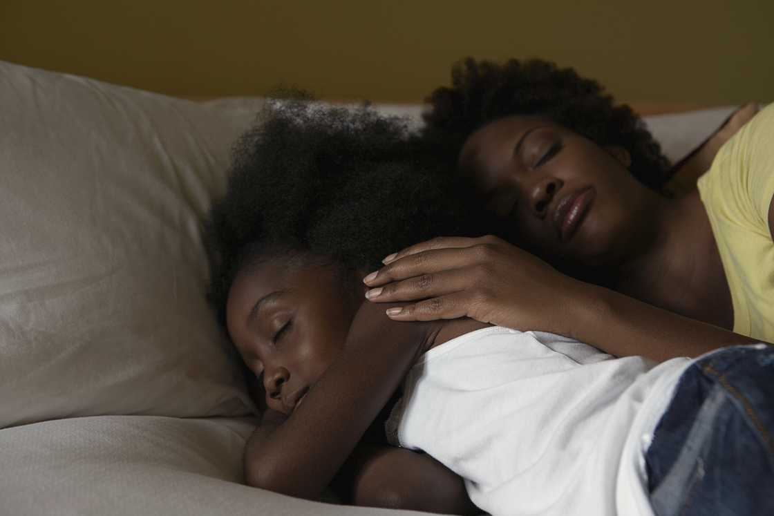 A mother hugging her daughter goodnight. A mother hugging her daughter goodnight.