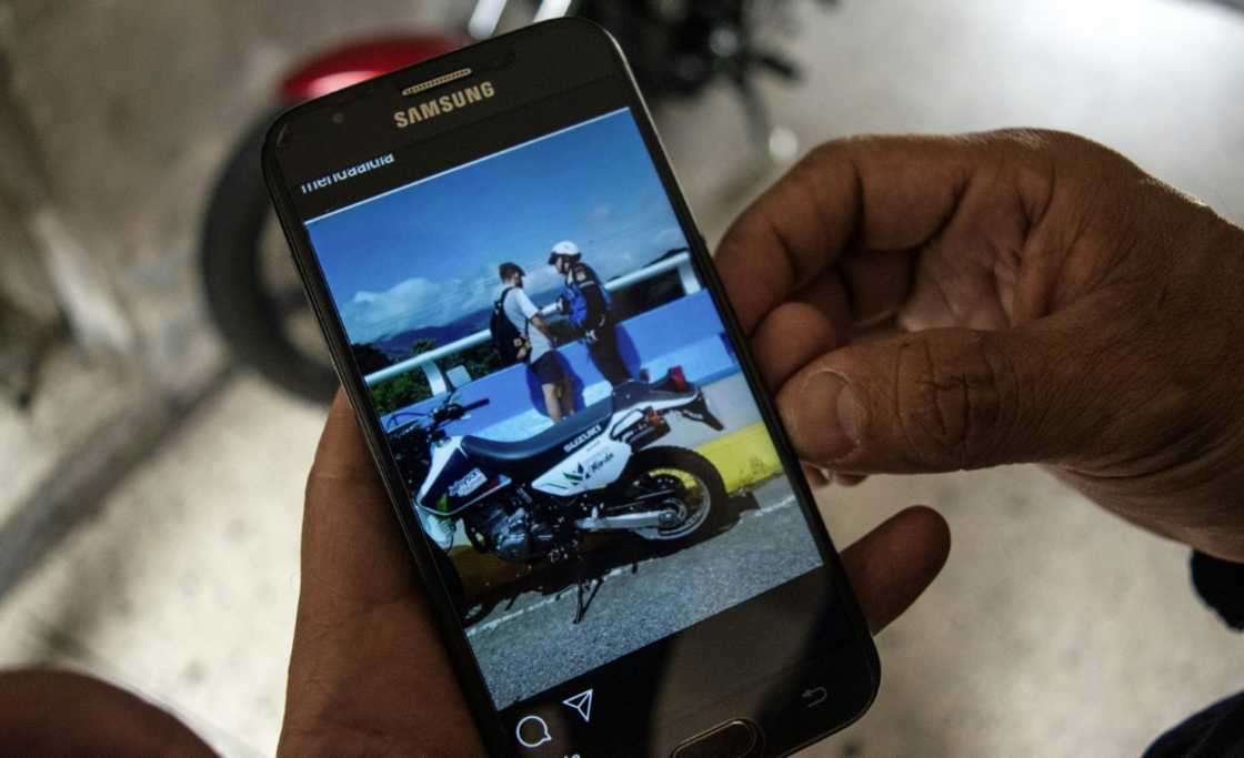 Venezuelan firefighter Henry La Cruz shows a picture of him speaking with a young man who was trying to commit suicide and whom he managed to rescue Venezuelan firefighter Henry La Cruz shows a picture of him speaking with a young man who was trying to commit suicide and whom he managed to rescue