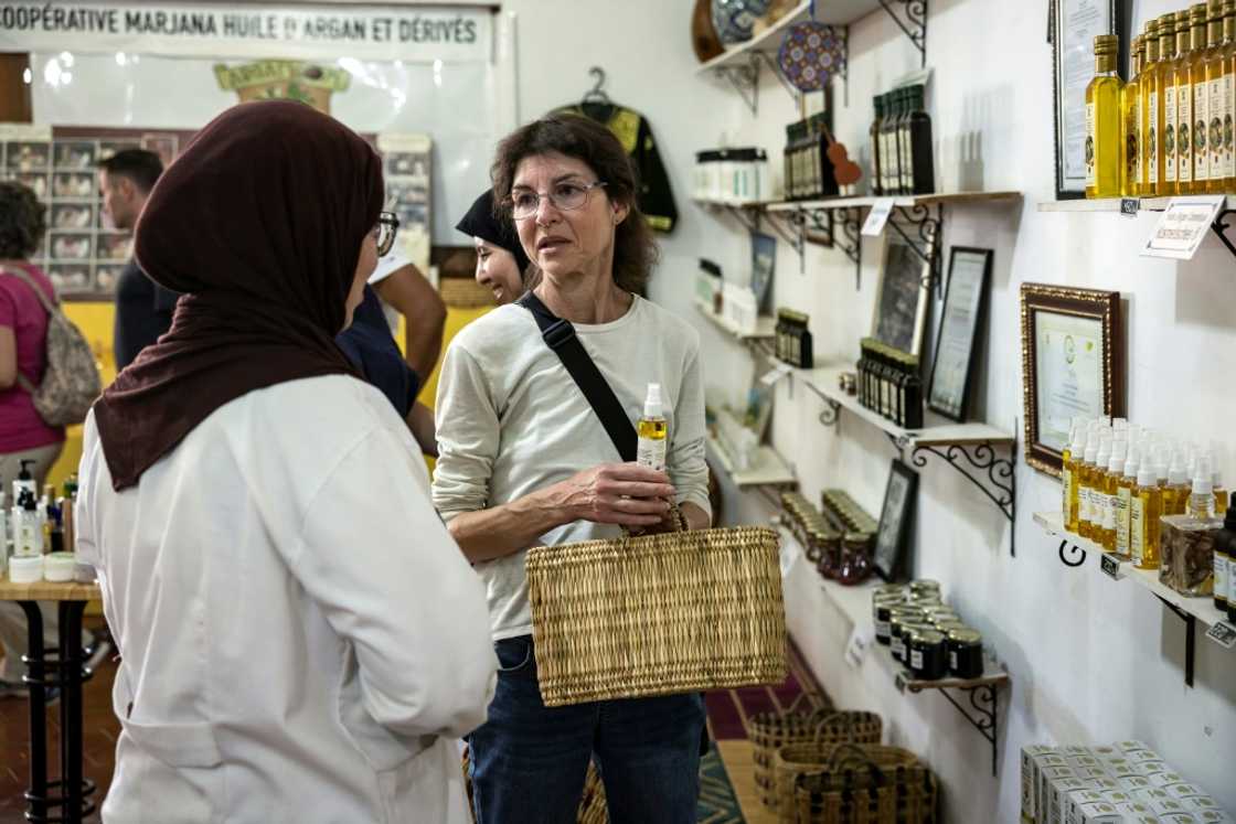 A tourist buys a bottle of argan oil -- the cooperative's younger workers prefer work in the gift shop A tourist buys a bottle of argan oil -- the cooperative's younger workers prefer work in the gift shop