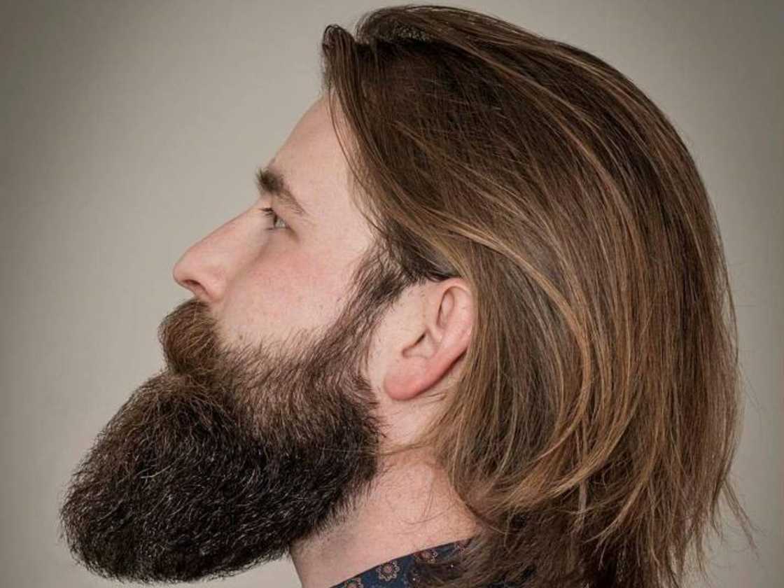 A man with a swept-back layered style faces away A man with a swept-back layered style faces away