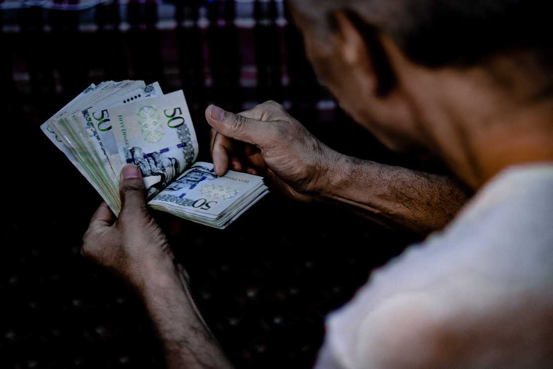 A man counting Libyan currency A man counting Libyan currency