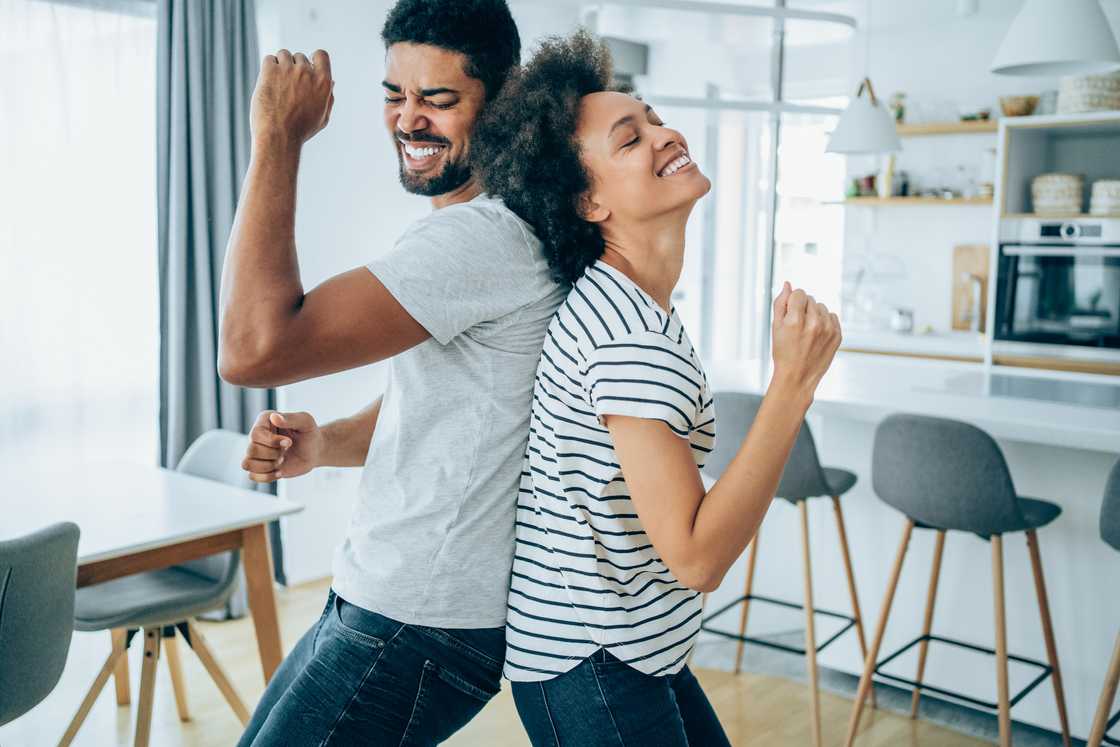 A young couple dancing together at home. A young couple dancing together at home.