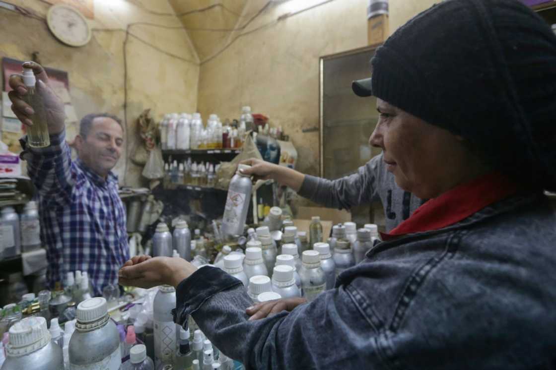 Customers flock to the tiny store in Damascus's old city, many flashing photos of high-end perfumes they want to replicate Customers flock to the tiny store in Damascus's old city, many flashing photos of high-end perfumes they want to replicate