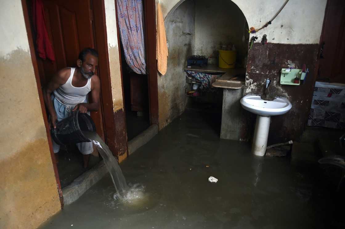 Karachi residents attempt to bail water from their shacks and dwellings using buckets, pots and jugs Karachi residents attempt to bail water from their shacks and dwellings using buckets, pots and jugs