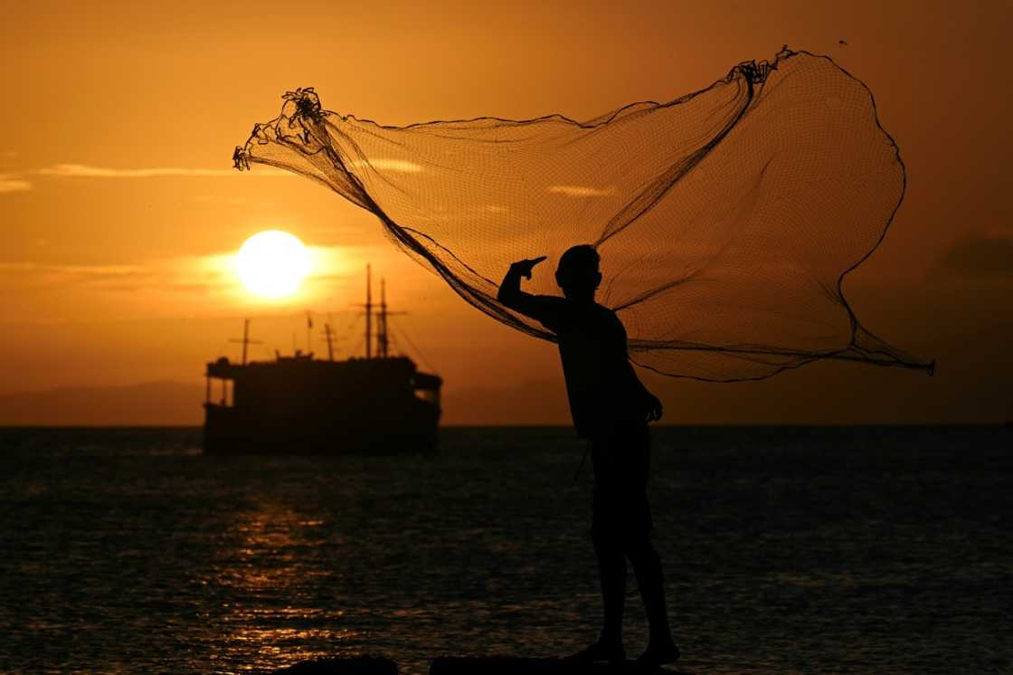 A man fishes at Juan Griego bay in Margarita Island, a Caribbean paradise in decline after a years-long economic and political crisis