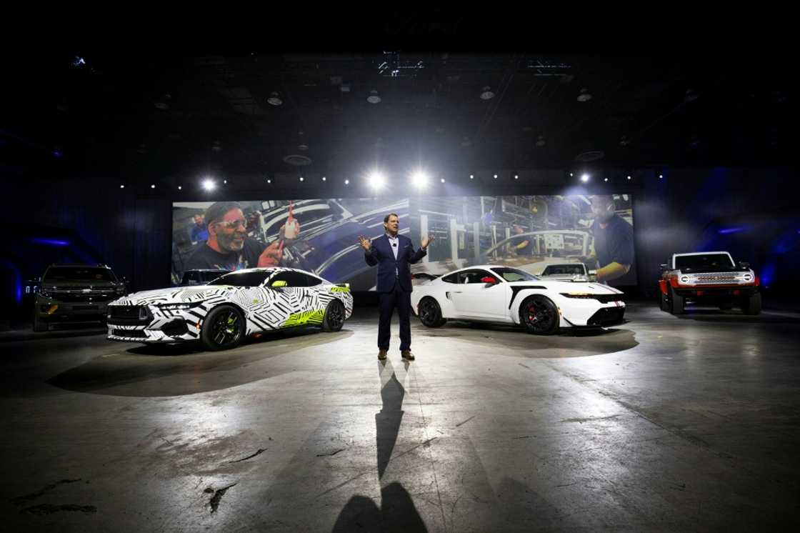 Ford Motor Company President and CEO Jim Farley stands between the Ford Mustang RTR (L) and the Ford Mustang GTD at the 2025 Detroit Auto Show
