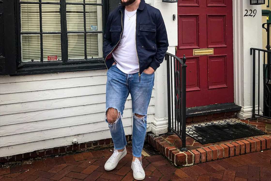 A man is wearing a pair of ripped jeans A man is wearing a pair of ripped jeans