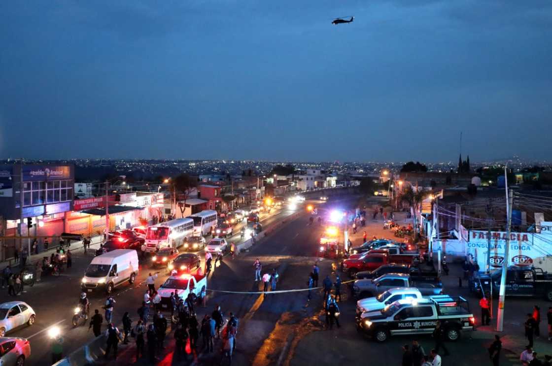 Police inspect an area where suspected gang members set a bus on fire in the western state of Jalisco