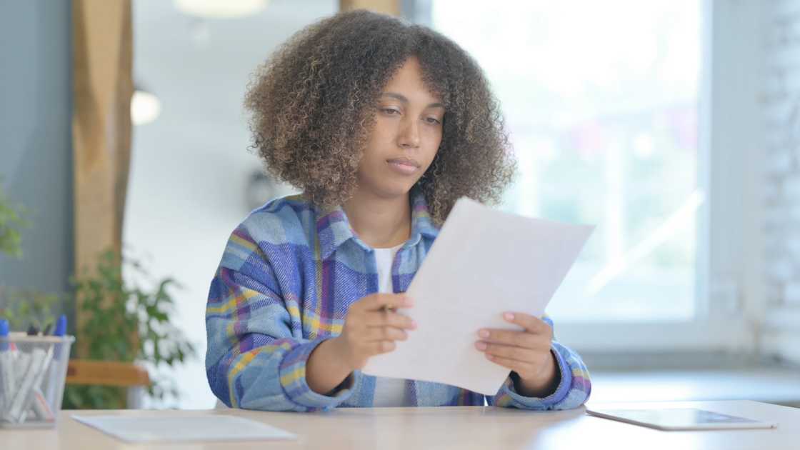A mother reading her child's report card. A mother reading her child's report card.
