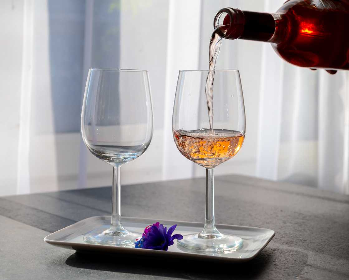 Someone pouring wine in a Pinot Noir wine glass Someone pouring wine in a Pinot Noir wine glass